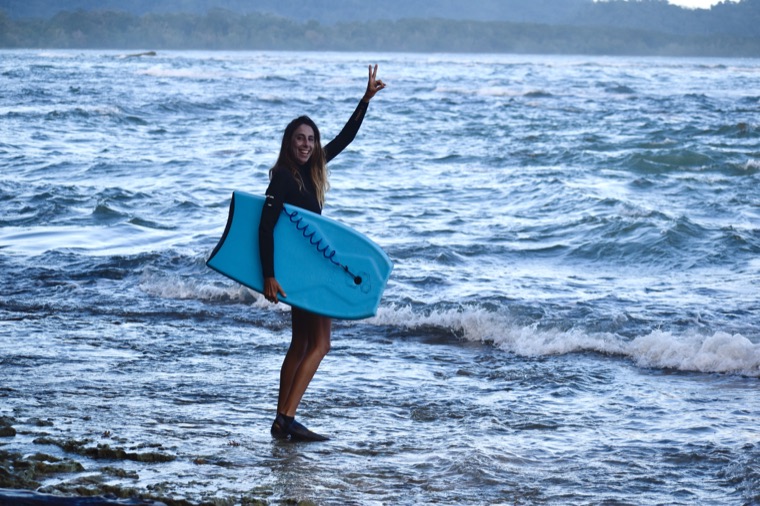 Anne-Cécile sourit avec son bodyboard au bord de l’océan.