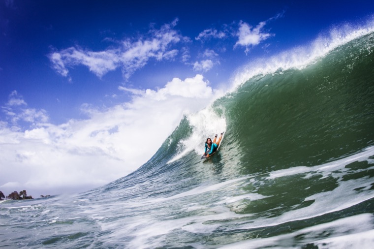 Anne-Cécile sur une grande vague bleue.