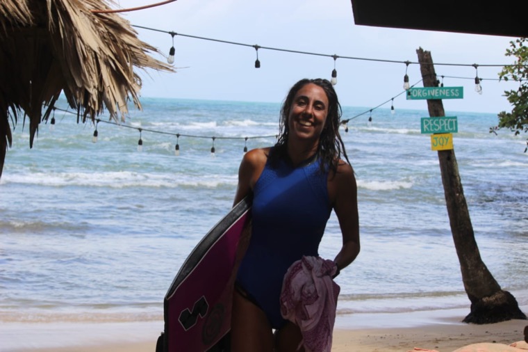 Anne-Cécile heureuse avec son bodyboard sur la plage.